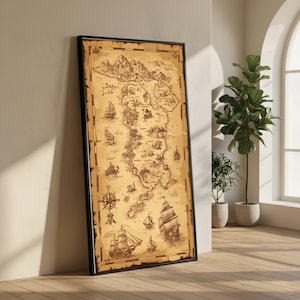 May include: A framed vintage map with a black border, showing an island with mountains, ships, and a compass rose. The map is printed on aged paper, giving a historical look. The map is leaning against a white wall.