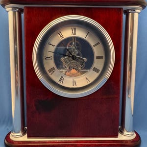 Rosewood Finish Mantel Clock With Silver Tone Columns Visible Skeleton Movement