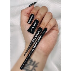May include: A hand model wearing black nail polish in different lengths and shapes. The nails are labeled with the nail shape and size: "Medium Almond", "Medium Square", "Long-Duck", "5XL-Stiletto", and "Extreme Square".