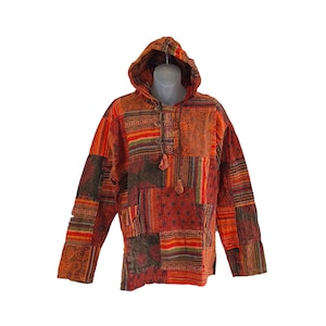 Puede incluir: Una sudadera con capucha de patchwork con un patrón geométrico en tonos naranja, rojo y marrón.
