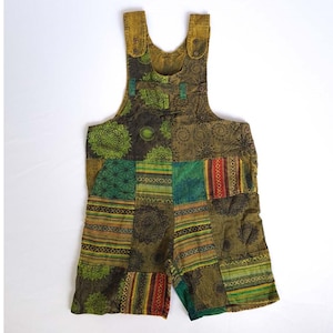 Puede incluir: Pantalón de peto de patchwork en tonos verdes, marrones y rojos con un patrón geométrico y floral.