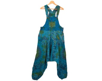 May include: Blue tie-dye overalls with a green and brown pattern. The overalls have a single pocket on the front and adjustable straps.