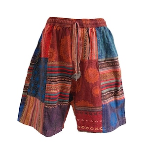 May include: Patchwork shorts with a colorful geometric pattern in shades of red, blue, and brown. The shorts have a drawstring waist.