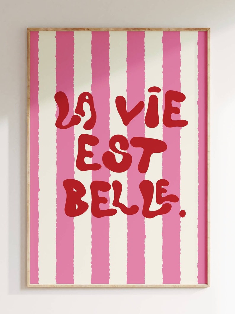 May include: A pink and white striped poster with the text "La vie est belle." in red.