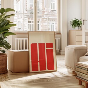 a modern living room with a large window, a white sofa, a potted plant, and a large red and white abstract artwork on the floor.