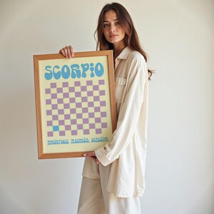 a woman holding up a framed game board