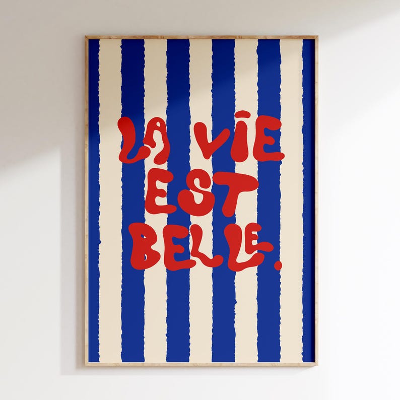 May include: A poster with blue and white stripes and the text "La vie est belle" in red.