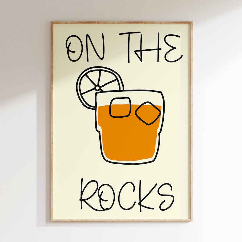 May include: A yellow background with black text that reads "ON THE ROCKS". A black outline of a glass with ice cubes and a slice of orange is in the center of the image.
