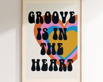 May include: A retro-style print with a heart shape made of concentric circles in pink, orange, blue, and yellow. The text "GROOVE IS IN THE HEART" is in black letters.