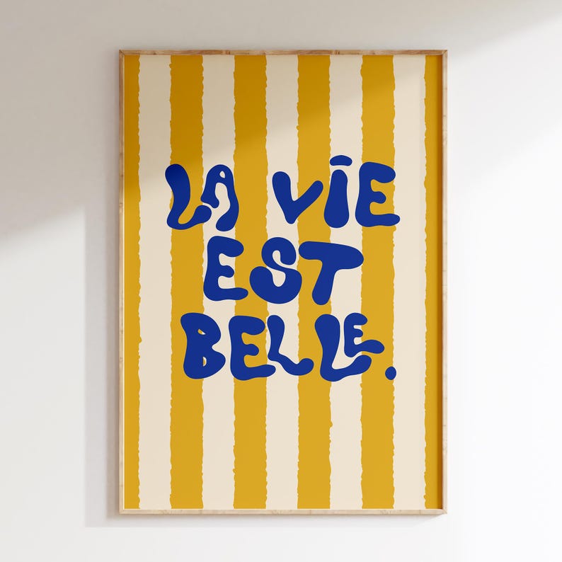 May include: A yellow and white striped poster with the text "La vie est belle" in blue.