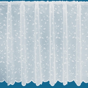 May include: White net curtain panel with a floral design. The curtain has a scalloped edge at the bottom and is made to be hung from a curtain rod. The delicate pattern features small flowers and leaves, creating a light and airy feel.