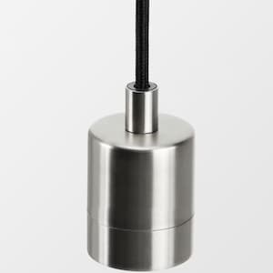 Puede incluir: Una toma de luz colgante de metal plateado con un cable negro.