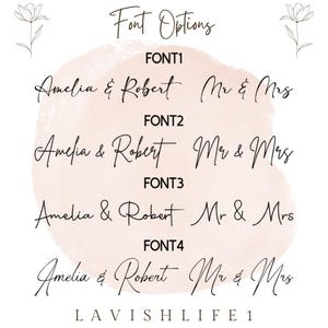 May include: A digital chart displaying four distinct font options for custom text. Each row features the names Amelia & Robert and the phrase Mr & Mrs in black script. The background is a soft pink watercolor shape with floral line art at the top.