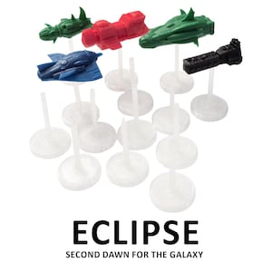 Puede incluir: Un conjunto de piezas de juego de naves espaciales en miniatura de colores verde, rojo, azul y negro, montadas sobre soportes de plástico transparente. El texto "ECLIPSE SECOND DAWN FOR THE GALAXY" está debajo.