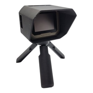 May include: A black rangefinder with a built-in sunshade, mounted on a black tripod. The rangefinder has a digital display with the word "XERO" on it.