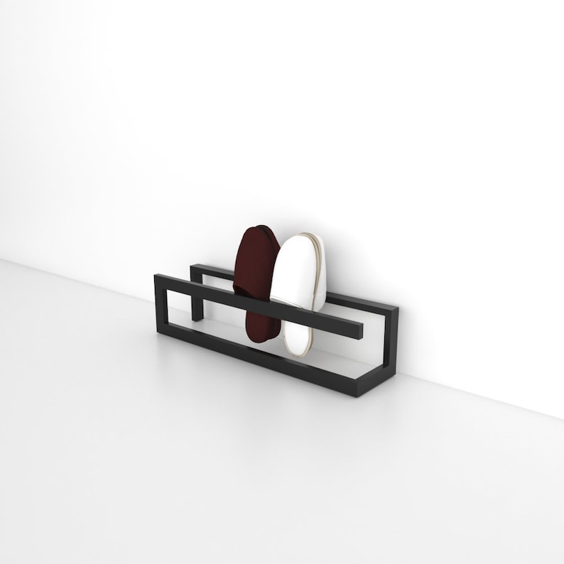 May include: A black metal shoe rack with two pairs of slippers, one white and one burgundy, hanging on it.