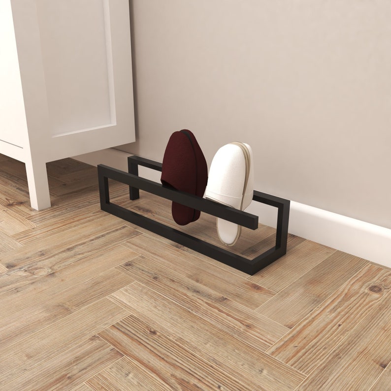 May include: A black metal shoe rack with two pairs of shoes on it. One pair is white and the other is burgundy.
