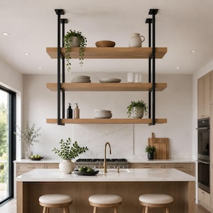 May include: A three-tier hanging shelf unit featuring light brown wooden planks supported by black metal frames. The shelves hold various kitchen items including a potted plant, ceramic bowls, plates, glasses, and two small pump bottles.