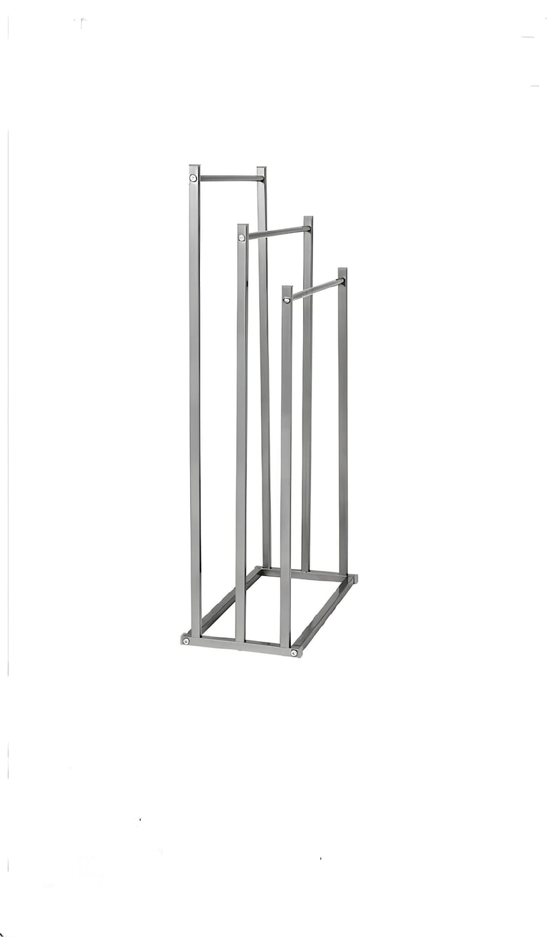 May include: A silver metal towel rack with three bars. The rack has a rectangular base and is made of thin metal.