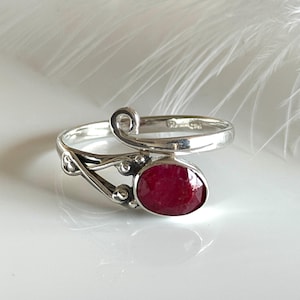 Könnte beinhalten: Eine weiße Keramik-Tasse mit schwarzem Henkel und dem Text "But First, Coffee" in fetter, schwarzer Schrift. Die Tasse steht vor einem verschwommenen Hintergrund. Die Tasse ist etwa 10 cm hoch.