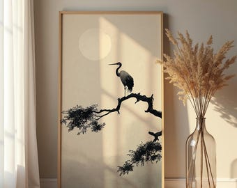 Könnte beinhalten: Ein gerahmter Kunstdruck mit einer minimalistischen Illustration im japanischen Stil. Ein schwarz-weißer Kranich sitzt auf einem Ast, vor einem weichen beigefarbenen Hintergrund mit einem Vollmond. Das Kunstwerk befindet sich in einem Holzrahmen.