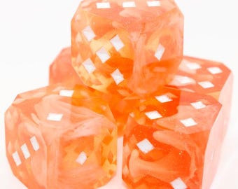 Könnte beinhalten: Vier orangefarbene Würfel mit weißen rautenförmigen Markierungen. Die Würfel haben ein marmoriertes Aussehen und sind auf weißem Hintergrund gestapelt. Ideal für Brettspiele.