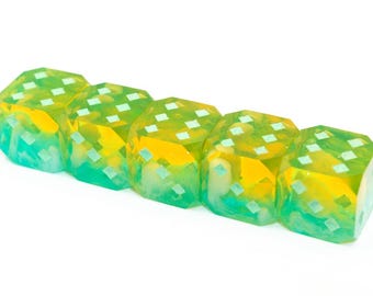 Könnte beinhalten: Fünf durchscheinende Würfel mit geometrischem Design. Die Würfel haben einen Farbverlauf von Gelb und Grün mit weißen quadratischen Mustern auf jeder Seite. Die Würfel sind diagonal vor weißem Hintergrund angeordnet.