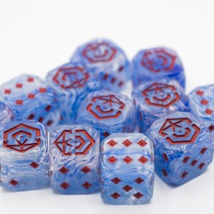 May include: A cluster of blue and white marbled dice, featuring red symbols and pips. The dice are displayed on a white background, highlighting their distinctive design and colour variations. These dice are suitable for tabletop games.