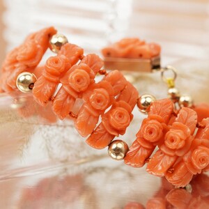 May include: A coral bracelet with carved rose and leaf details, strung with gold beads.