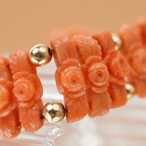 May include: A coral bracelet with carved rose motifs and gold beads.