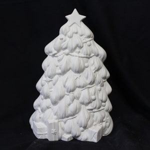 May include: White ceramic Christmas tree with a star on top and ornaments hanging from the branches. The tree is decorated with presents at the base.