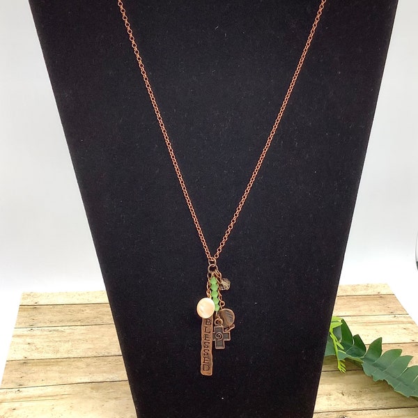 This necklace is on Antique copper chain and measuring 21 1/2 inches. Blessed charm as well as cross charm along with light green crystals.