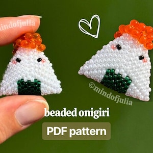 May include: Two beaded onigiri, triangular rice balls, with white beads, green seaweed, and orange roe. The text "beaded onigiri PDF pattern" is displayed. One onigiri is held by a hand. A white heart is drawn on the green background.