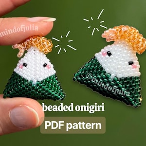 May include: Two beaded onigiri, a Japanese rice ball, are shown. The onigiri are triangular, with white, green, and orange beads. The text "beaded onigiri PDF pattern" is displayed in a green box. The background is a blurred green.
