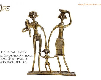 May include: A brass sculpture of a tribal family. The family consists of a man, a woman, and a child. The man is holding a stick, the woman is carrying a basket on her head, and the child is holding onto the woman's hand. The sculpture is 6 inches by 3.5 inches and weighs 0.35 kg.