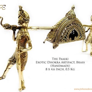 May include: A gold-colored brass sculpture of a palanquin, a traditional Indian litter, carried by two figures. The palanquin is ornate with intricate details and the figures are dressed in traditional attire. The sculpture is handmade and measures 8 x 4.6 inches. "THE PAALKI EXOTIC DHOKRA ARTIFACT, BRASS (HANDMADE) 8 X 4.6 INCH, 0.5 KG"