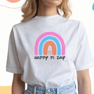 K&ouml;nnte beinhalten: Wei&szlig;es T-Shirt mit einem Regenbogen-Design und dem Text "Happy Pi Day" mit einem Pi-Symbol in der Mitte des Regenbogens.