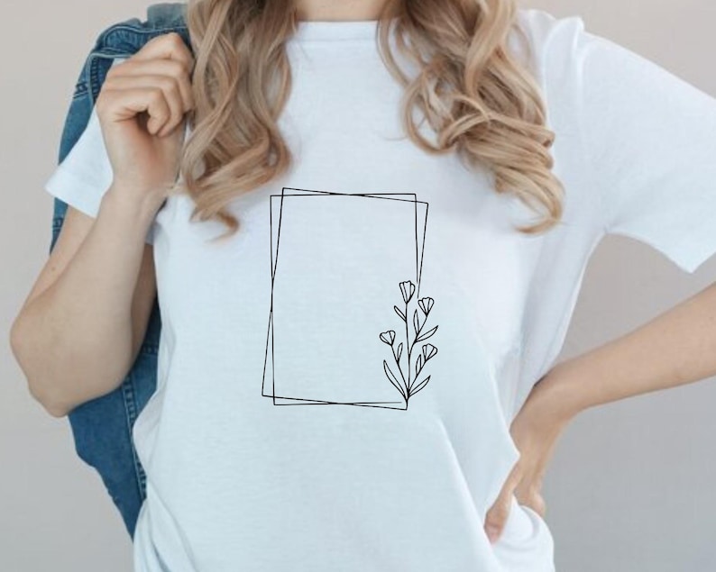 May include: A white t-shirt with a simple black line drawing of a square frame with a small floral design inside.