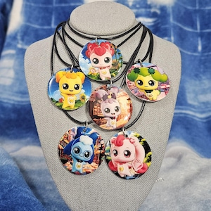 May include: Six colorful necklaces with round pendants featuring cartoon characters. Each pendant has a different character with a unique design and color scheme. The necklaces are made of black cord and are displayed on a gray mannequin.