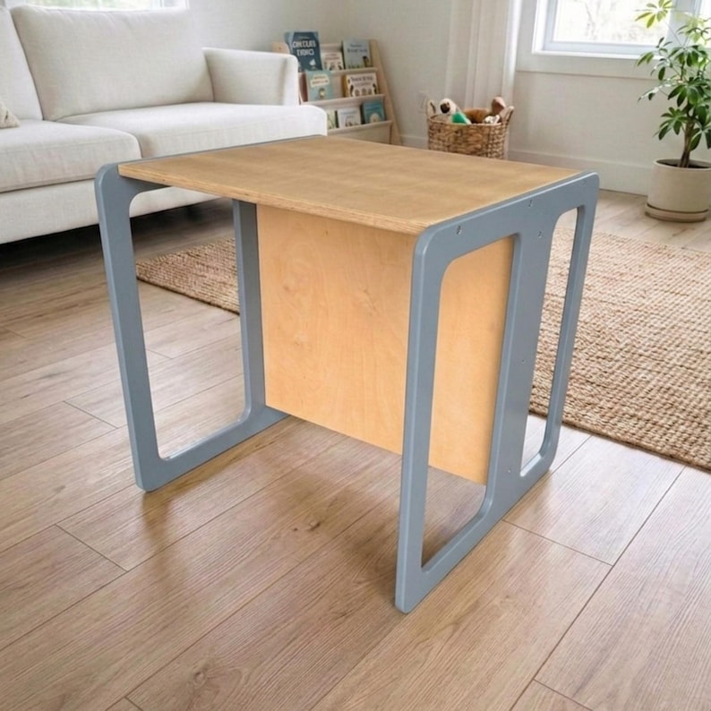 May include: A small, light-colored wooden desk with a rectangular top and gray frame. The desk has a natural wood finish on the top and a light gray frame. The desk is approximately 30 inches long, 20 inches wide, and 20 inches tall.