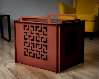 May include: A reddish-brown pet house with a handle on top and a decorative geometric pattern on the front. The house has a rounded doorway and is made of metal. The pet house is designed for indoor use.