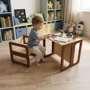 May include: A child's wooden desk and chair set with a light wood tabletop and dark brown legs. The child is drawing with crayons on a piece of paper. Toy dinosaurs are on the desk. The set is in a child's playroom.