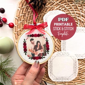 May include: An embroidery hoop featuring a family photo, framed by red roses and green leaves. A red ribbon and bow adorn the hoop. The image also includes a PDF printable stick and stitch template.