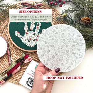 Puede incluir: Un kit de bordado con tem&aacute;tica navide&ntilde;a con un dise&ntilde;o de huella de mano. El kit incluye un aro de tela verde con un patr&oacute;n de huella de mano, una tela redonda con un patr&oacute;n navide&ntilde;o e hilo de bordar. El texto dice "SIZE OPTIONS" y "HOOP NOT INCLUDED".