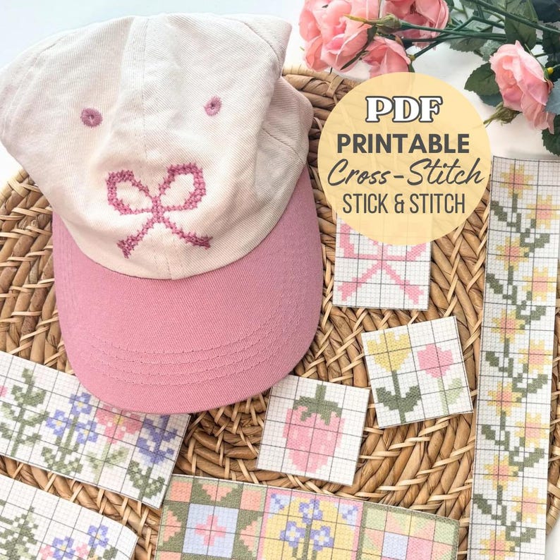 May include: A light pink baseball cap with a pink embroidered bow design. The cap is next to several cross-stitch patterns, including a bow, flowers, and a strawberry. The image also includes a PDF printable cross-stitch sticker.