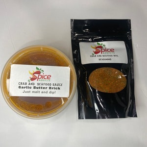 May include: Two containers of crab and seafood seasoning. One container is a clear plastic jar with a red and yellow label that reads "Spice Addicts Crab and Seafood Sauce Garlic Butter Brick Just melt and dip!" The other container is a black plastic bag with a red and yellow label that reads "Spice Addicts Crab and Seafood Boil Seasoning".