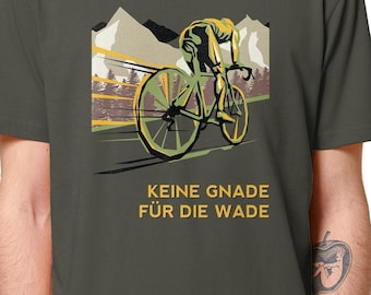 May include: A dark green t-shirt with a vintage-style illustration of a cyclist riding a bicycle uphill. The text "KEINE GNADE FÜR DIE WADE" is printed in yellow below the illustration.