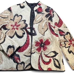 May include: Quilted jacket in cream with a floral design in red, black, and tan. The jacket has a mandarin collar and black trim. The floral pattern is a key feature of the jacket's design, which is visible across the garment.