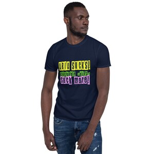 Peut inclure: Un t-shirt bleu marine avec un imprimé graphique jaune, vert et rose qui dit "ARIA SUCKS! Clickable - Diva - Suck More!"