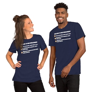 May include: Two people wearing navy blue t-shirts with white text that reads "Welcome to Web Development!" The text is followed by a list of humorous statements about web development.